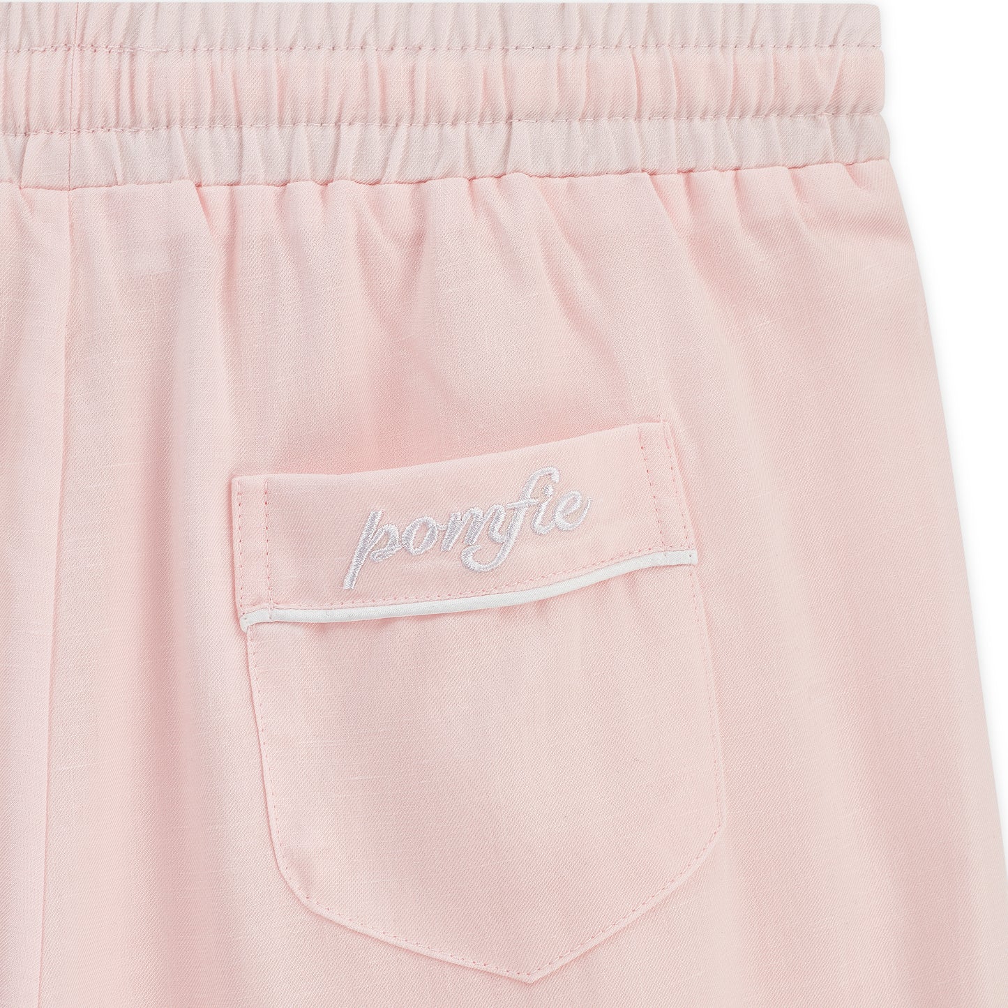 baby pink pyjama bottoms. Back pocket detail with white piping and pomfie logo embroidered.