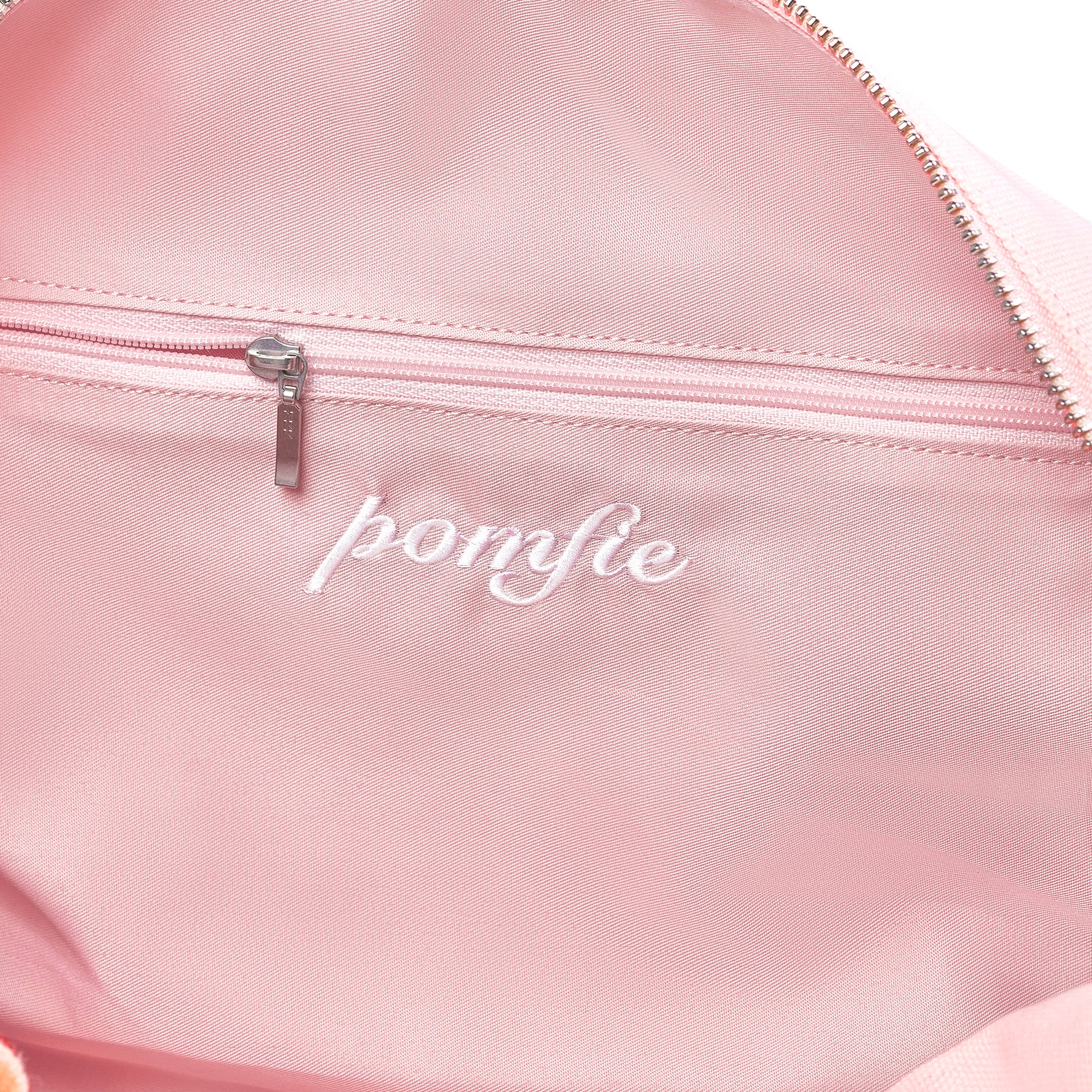 close up inside of twill baby pink cotton bag. ykk silver zip detail inside pocket.